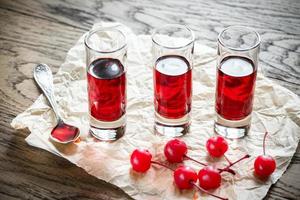 bicchieri di acquavite di ciliegie con ciliegie da cocktail foto