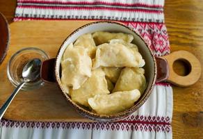 gnocchi in una pentola su un tavolo di legno foto