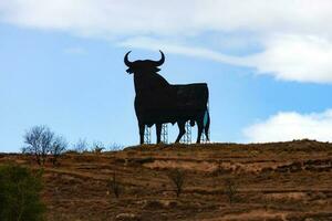 Toro silhouette su un' pendio deserto paesaggio nel Spagna foto