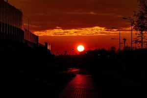 rosso tramonto nel il città con un' strada e a piedi coppia di persone nel amore foto