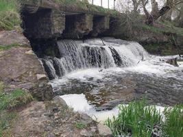 fluente acqua artificiale cascata su il fiume foto