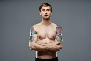 sport uomo ritagliata Visualizza allenarsi tatuaggio su braccia grigio sfondo foto