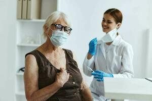 vecchio donna indossare medico maschera nel il ospedale per vaccinazioni vaccino passaporto foto