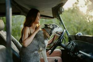 donna e sua rauco cane felicemente in viaggio nel auto Sorridi con denti autunno camminare con animale domestico, viaggio con cane amico foto