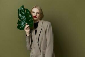 ritratto di un' donna nel cappotto rosso labbra moda palma foglia studio modello inalterato foto