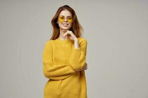 dai capelli rossi donna nel un' giallo maglione moda bicchieri studio modello foto