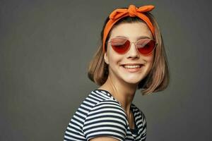 donna con arancia bendare su sua testa indossare occhiali da sole in posa moda lusso foto