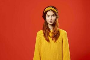 donna nel un' giallo maglione con un' bendare su sua testa fricchettone Accessori studio foto