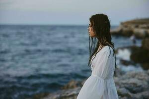 bellissimo donna nel bianca vestito a il mare spiaggia natura foto