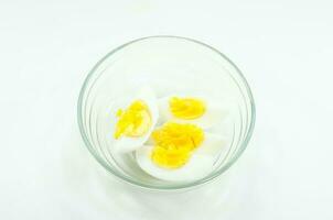 affettato difficile bollito uova nel tazza su bianca sfondo. foto