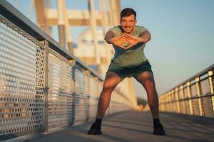 un' uomo nel un' verde maglietta fare esercizi foto