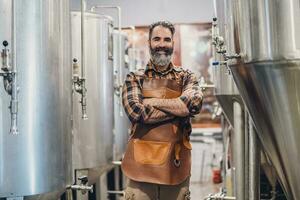 uomo è Lavorando a mestiere birra fabbrica. lui è operativo macchinari nel birrificio. piccolo famiglia attività commerciale, produzione di mestiere birra. foto