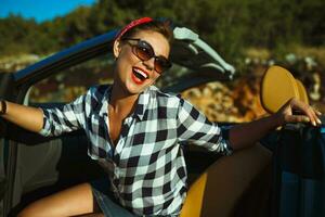 bellissimo perno su donna seduta nel cabriolet, godendo viaggio su lusso moderno auto con Aperto tetto foto