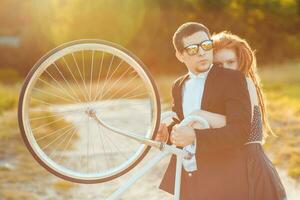 giovane elegante tipo con ragazza e il bicicletta all'aperto foto