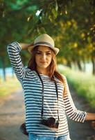 bello giovane donna nel un' cappello equitazione un' bicicletta nel un' parco foto