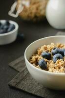 muesli con mirtillo nel ciotola su buio tovagliolo. foto