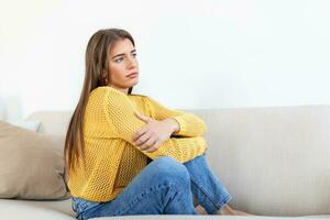 ansioso preoccupato donna seduta su divano a casa. frustrato confuso femmina si sente infelice, i problemi nel personale vita, litigare rompere su con fidanzato e inaspettato gravidanza concetto foto