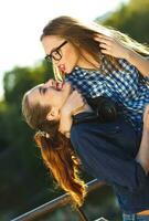 Due giocoso ragazze avendo divertimento all'aperto a tramonto leggero foto