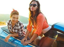 Due giovane ragazze avendo divertimento nel il cabriolet all'aperto foto