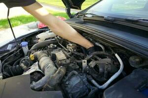 meccanico controllo il motore. auto servizio, meccanico riparazione il motore. lavoratore ispezionando auto motore dentro. foto