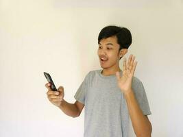 asiatico uomo dire Ciao gesto su video chiamata isolato su bianca foto