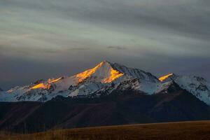 il primo raggi di il alba sole su il nevoso montagna picchi. atmo foto