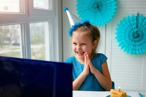 poco contento ragazza applaude sua mani, celebra compleanno attraverso il Internet nel quarantena volta, auto-isolamento e famiglia i valori, in linea compleanno foto