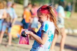 bambino nel verde colori holi. holi facciale tiro su primavera colore Festival di holi. holi celebrazione concetto. il ritratto ride il ragazza a dipingere festa foto