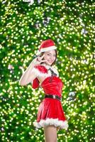 bella asiatico ragazza nel Santa costume per Natale con notte leggero foto
