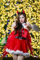 bella asiatico ragazza nel Santa costume per Natale con notte leggero foto