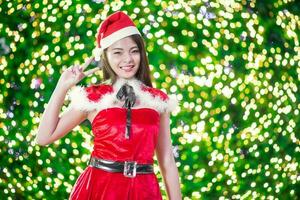 bella asiatico ragazza nel Santa costume per Natale con notte leggero foto