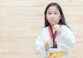 asiatico taekwondo ragazza su agire su legna sfondo foto