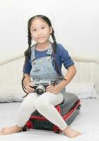 carino ragazza hold Vintage ▾ telecamera e sedersi su valigia foto