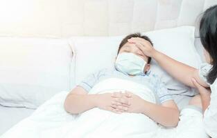 malato ragazzo con igienico maschera posa su letto foto