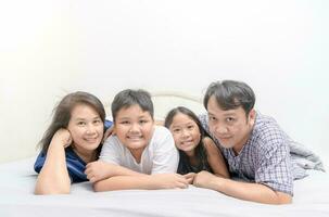 asiatico contento giovane famiglia dire bugie nel letto insieme foto