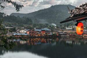 lanterne cinesi e barche nel lago con tramonto sul ban rak thai foto