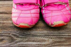 vecchio bambino scarpe da ginnastica su di legno sfondo foto