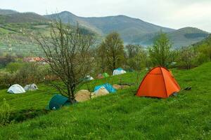 campeggio tende su un' verde prato nel il montagne nel primavera. riposo con il tenda nel natura foto