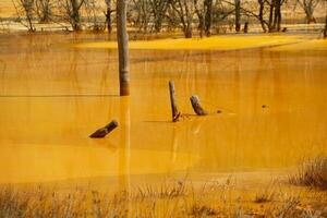 un' lago contaminati con tossico rifiuto nel il occidentale montagne di Romania. natura inquinamento a partire dal rame il mio. ecologico catastrofe o ambientale disastro foto