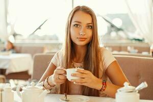 bella donna potabile tè nel un' bar nel un' soleggiato estate giorno. foto