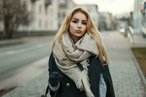 bellissimo giovane donna nel un' elegante cappotto e un' a maglia sciarpa foto