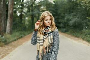 elegante bellissimo ragazza nel autunno Abiti con un' sciarpa su il sfondo di autunno parco foto