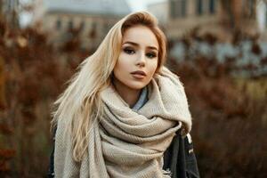 bellissimo giovane donna nel un' caldo sciarpa in piedi nel autunno parco. foto