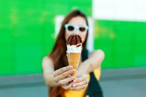 bellissimo giovane ragazza con ghiaccio crema su il strada. ghiaccio crema nel mani foto