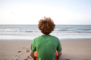 indietro Visualizza di un' uomo seduta su un' spiaggia. ai generato foto