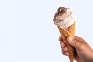 mano Tenere delizioso biscotti e crema ghiaccio crema nel un' croccante cialda cono con copia spazio. ai generato foto