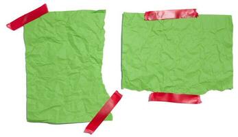 verde strappato pezzi di carta nastrate con elettrico nastro su un' bianca isolato sfondo foto