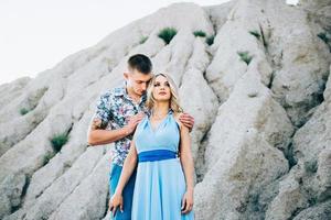 ragazza bionda in un vestito azzurro e un ragazzo con una camicia leggera in una cava di granito foto