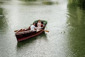 una gita in barca per un ragazzo e una ragazza lungo i canali e le baie del fiume foto