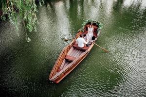 una gita in barca per un ragazzo e una ragazza lungo i canali e le baie del fiume foto